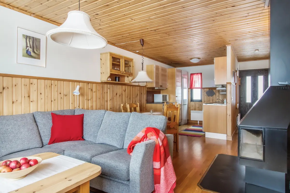 Vardagsrum med soffa och öppet kök i lägenhet i markplan