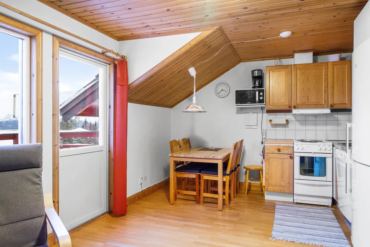 Kök och matplats under snedtak i lägenhet på övre plan