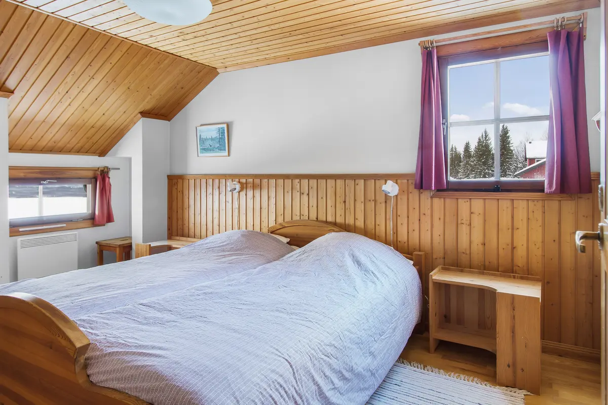 Sovrum med dubbelsäng under snedtak