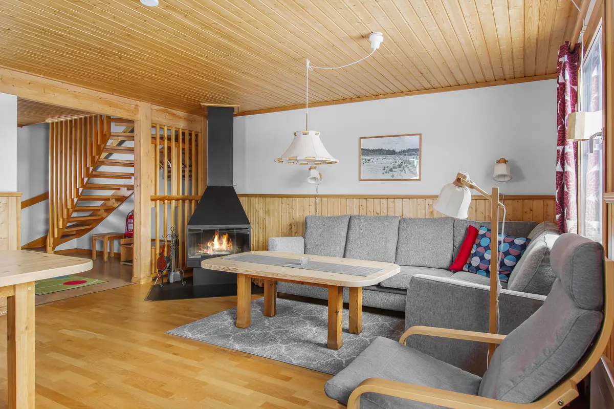 Vardagsrum med öppen spis och trappa till övervåningen